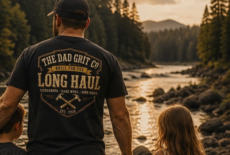 A dad wearing The Dad Grit Co. Built for the Long Haul tee with his children beside a river